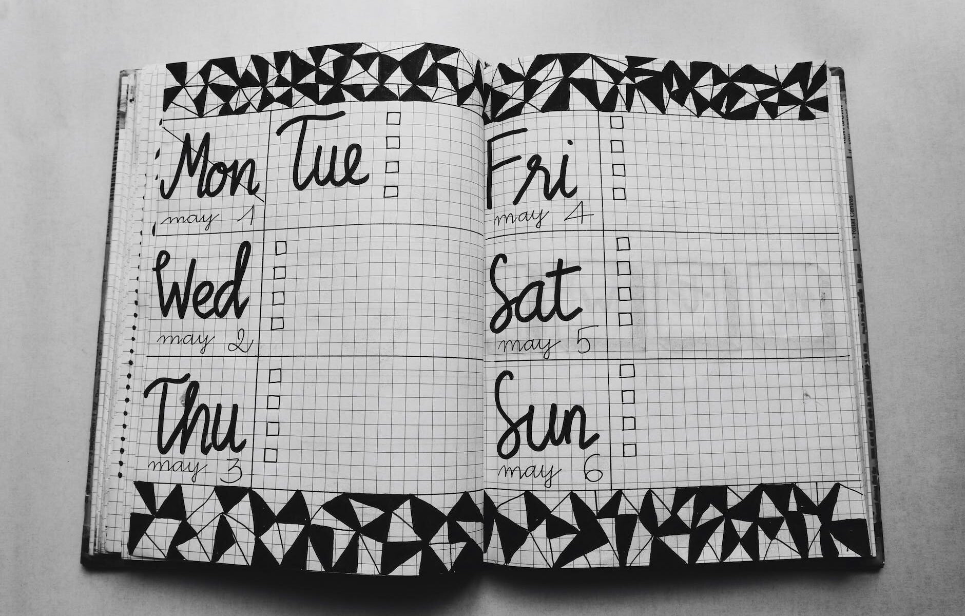 white and black weekly planner on gray surface